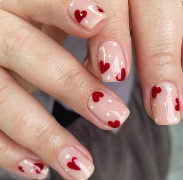 Natural nude nails with scattered red hearts Valentine's design