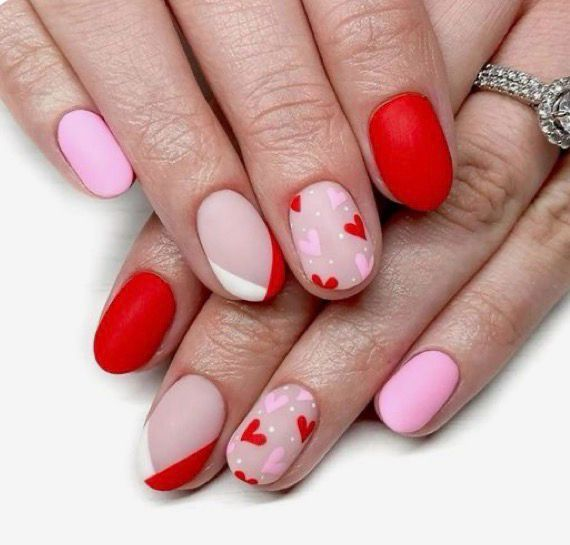 Red, pink, and nude nails with scattered red hearts